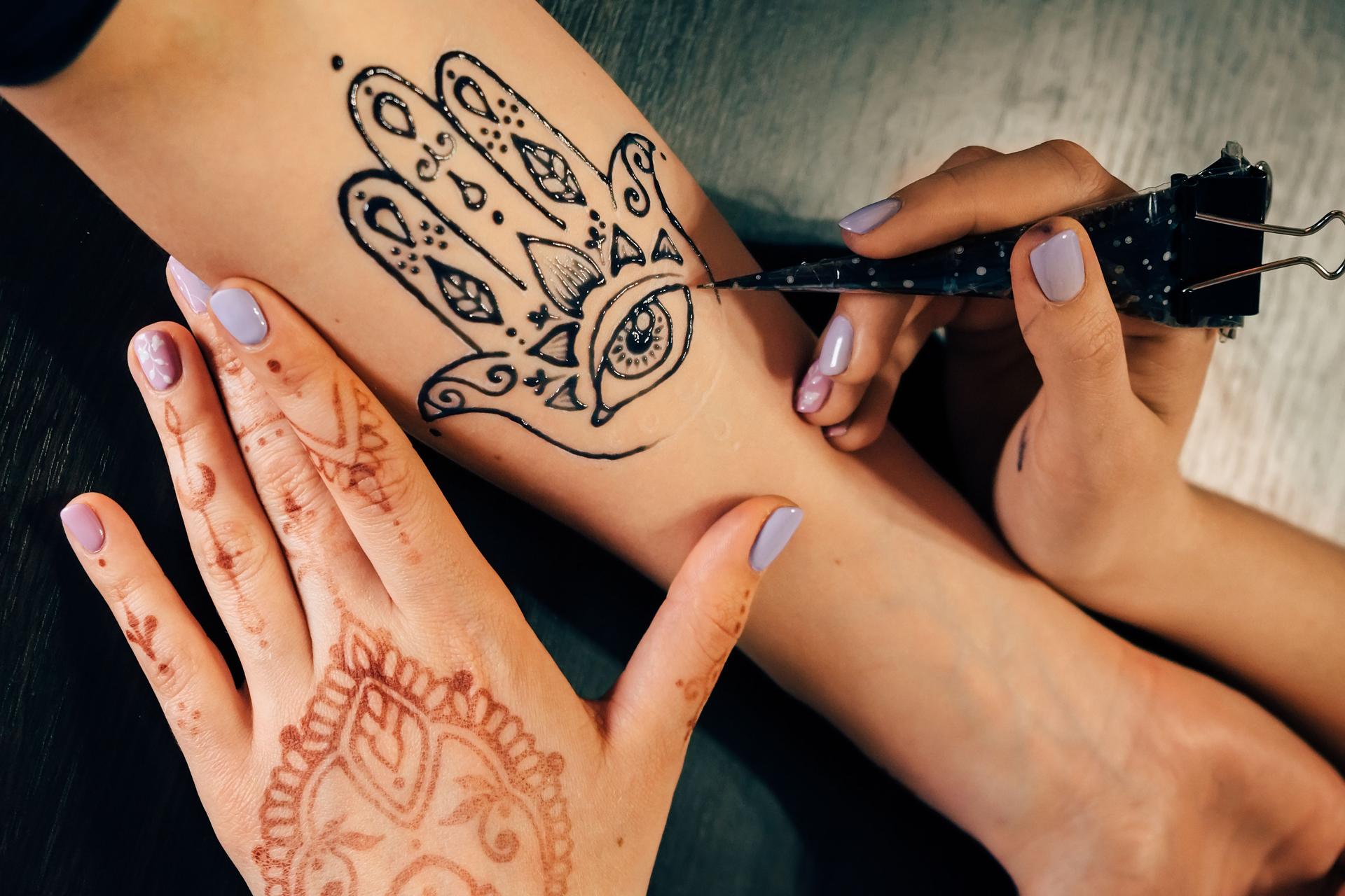 Artiste en appliquant le tatouage de henna mehndi part femelle